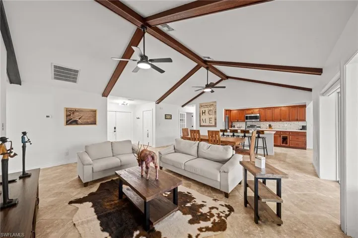 Living room with a ceiling fan and light tile patterned floors