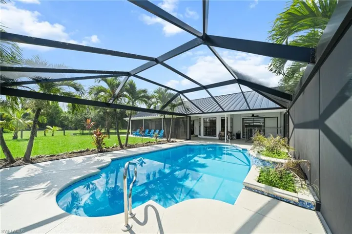 Outdoor pool featuring a patio area, a yard, a ceiling fan, and a lanai