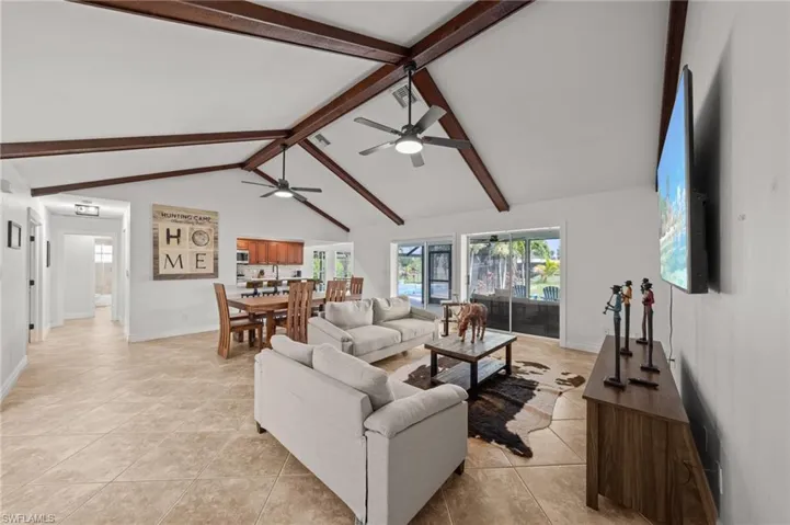Living room with a ceiling fan and light tile patterned floors