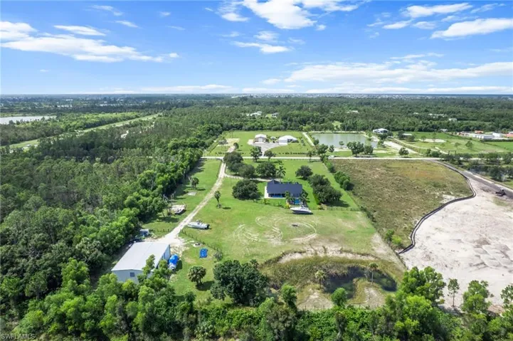 Aerial view of property's location featuring a heavily wooded area and a nearby body of water