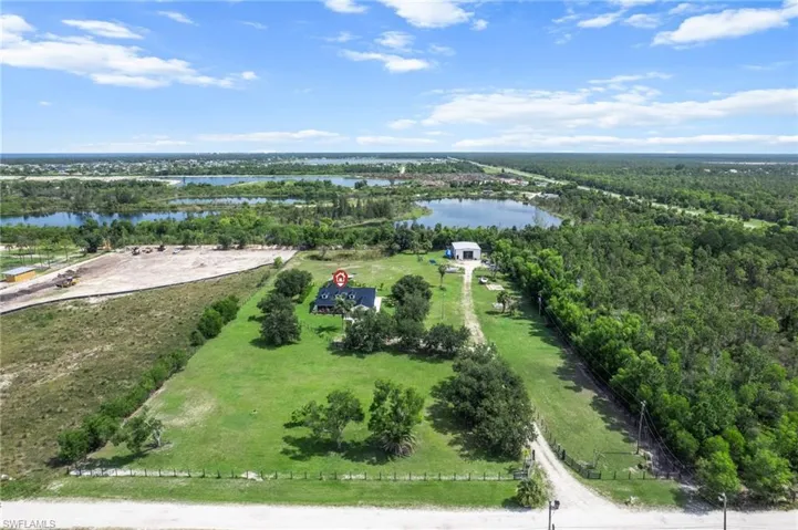 Drone / aerial view of a nearby body of water and a forest