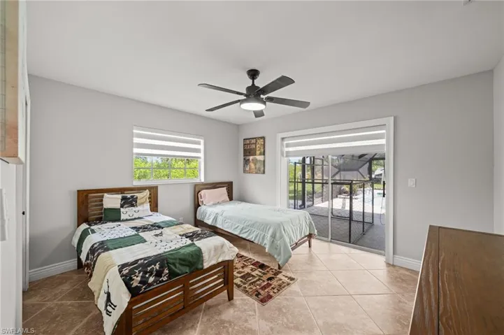 Tiled bedroom with access to exterior and a ceiling fan