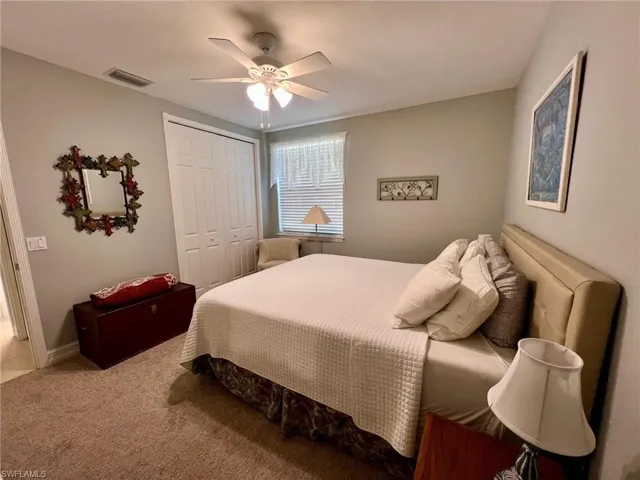 Bedroom with a closet, ceiling fan, and carpet floors