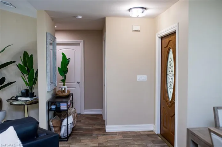 Foyer with wood finished tile floors and baseboards