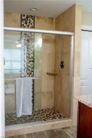 Full bath with a shower stall and vanity