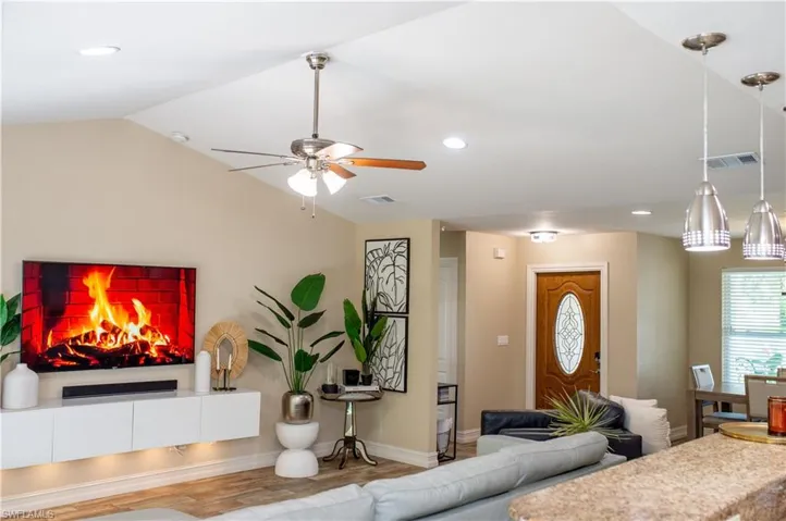 Living area featuring wood tile finished floors, recessed lighting, lofted ceiling, and a ceiling fan
