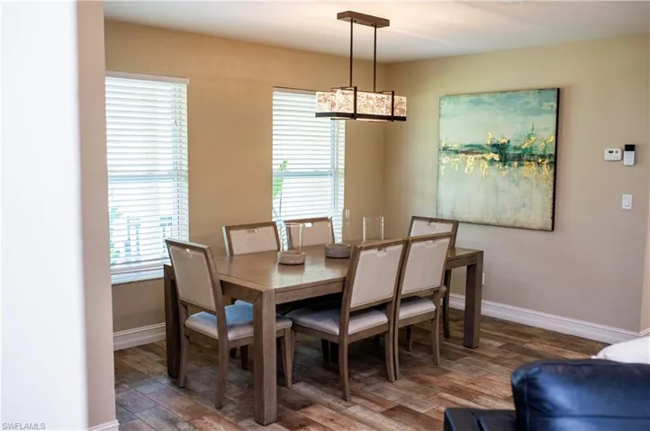 Dining room featuring wood tile finished floors and designer light fixture