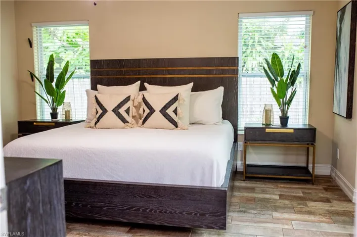 Bedroom with tile wood finished floors and baseboards