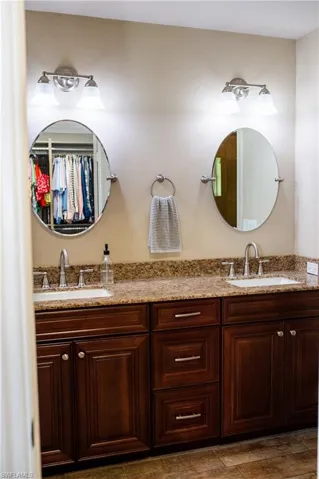 Master bath with a walk in closet and double vanity