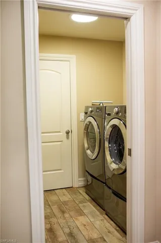 Washroom featuring wood-style tile floors and washer and dryer