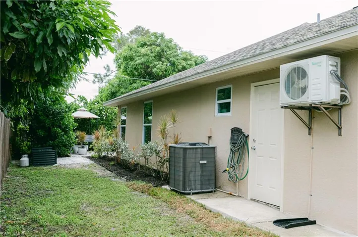 View of property exterior featuring stucco siding, air-conditioning unit and split unit for garage