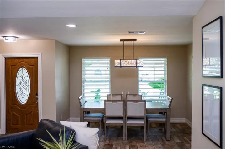 Dining space featuring wood-style tile floors and recessed lighting