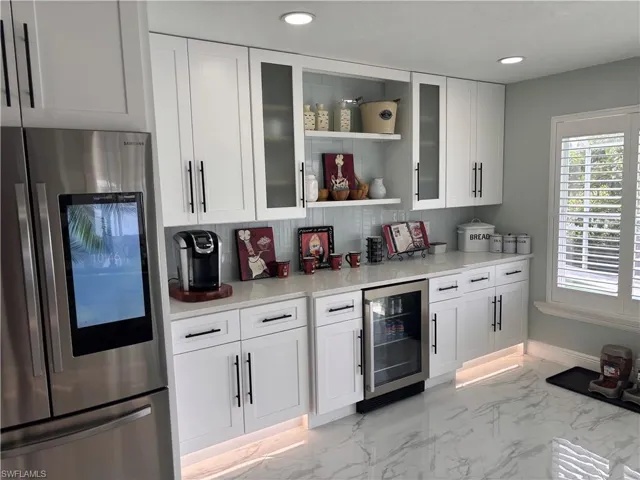Bar area with smart refrigerator, beverage cooler, light marble finish flooring, tasteful backsplash, and recessed lighting