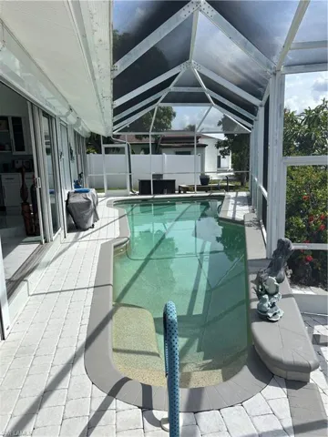 View of swimming pool with a patio area and a lanai