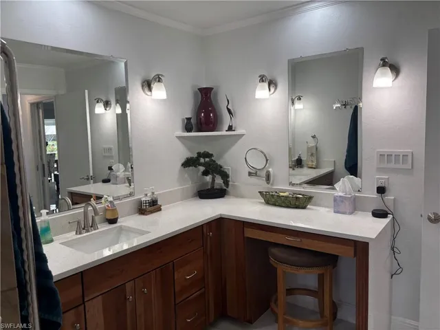 Bathroom with ornamental molding and vanity
