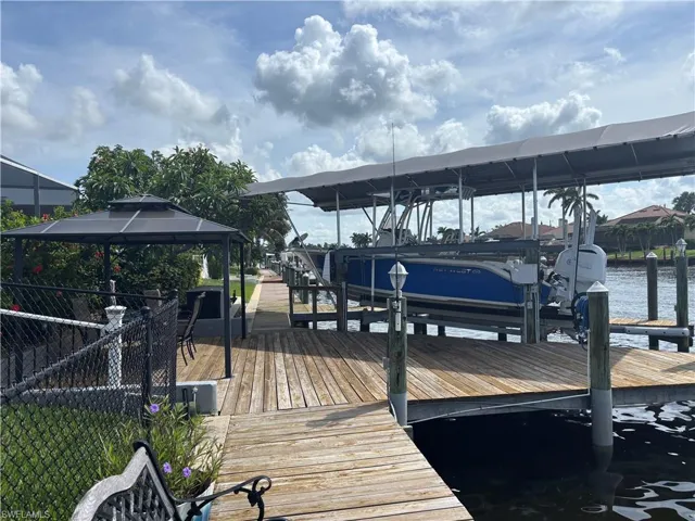 Dock area featuring boat lift, a gazebo, and a water view