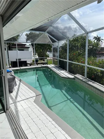 Outdoor pool with a lanai and a patio area