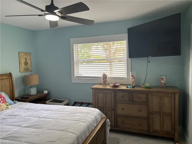 Bedroom with light marble finish floors and ceiling fan