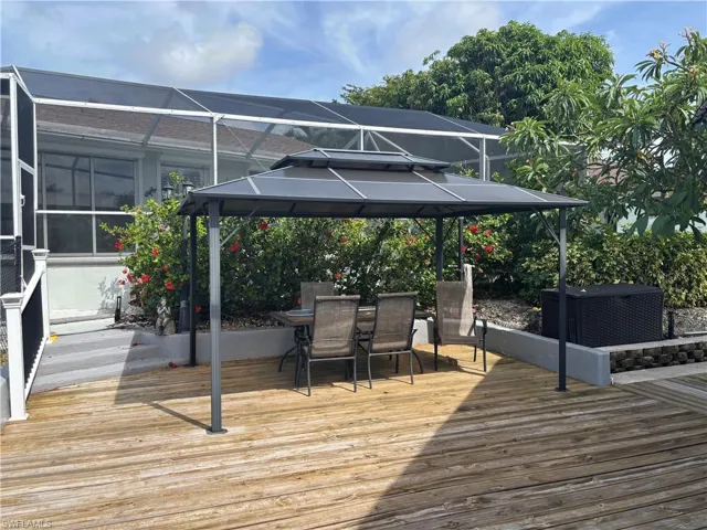 Deck featuring a gazebo, a lanai, and outdoor dining space