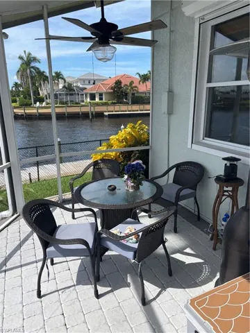 Balcony with a water view, ceiling fan, and outdoor dining space