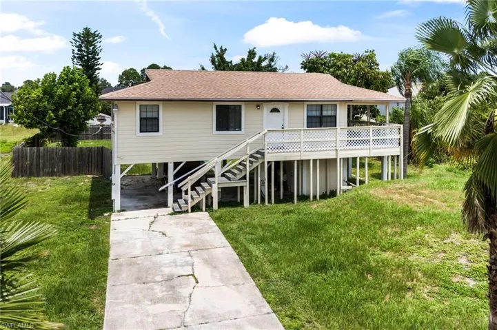 View of front facade featuring a carport and a front yard