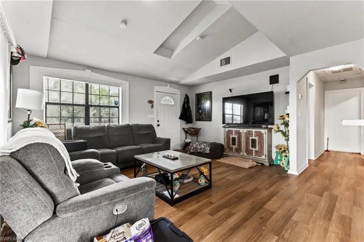 Living room featuring hardwood / wood-style flooring and lofted ceiling