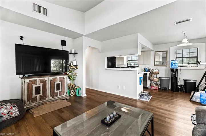Living room featuring a towering ceiling and dark wood-type flooring