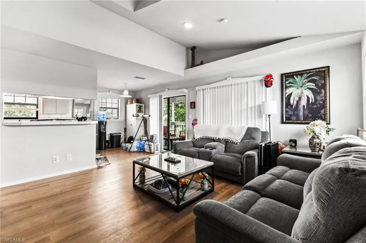 Living room with wood-type flooring and high vaulted ceiling