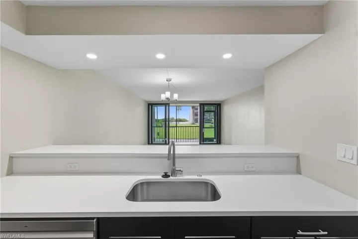 Kitchen with a peninsula, recessed lighting, pendant lighting, dark cabinetry, and stainless steel dishwasher
