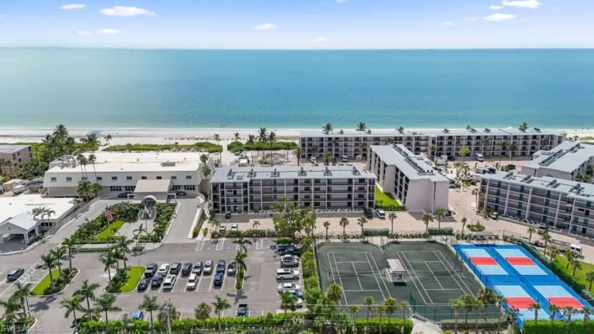 Aerial view of apartment complex / building and waterfront with a beach