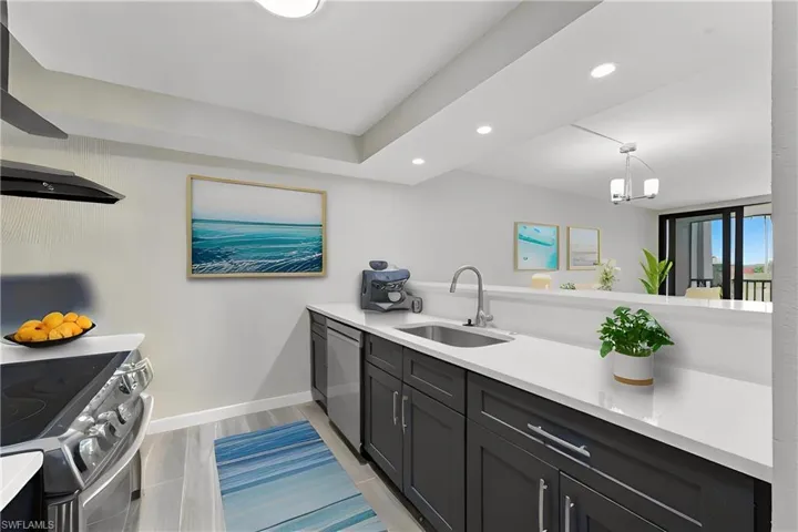 Kitchen featuring recessed lighting, ventilation hood, light stone countertops, appliances with stainless steel finishes, and pendant lighting