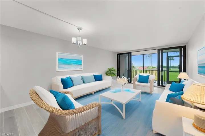 Living area with wood finished floors, floor to ceiling windows, and a chandelier