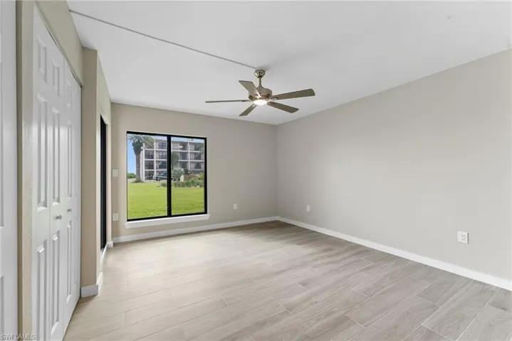 Unfurnished bedroom featuring a closet, wood finish floors, and a ceiling fan