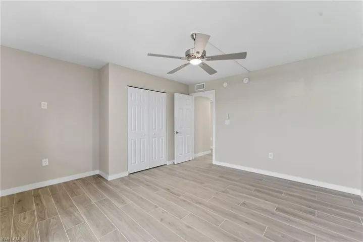 Unfurnished bedroom with wood tiled floors, a ceiling fan, and a closet