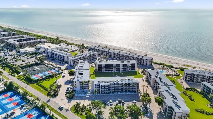 Aerial view of apartment complex and waterfront with a beach