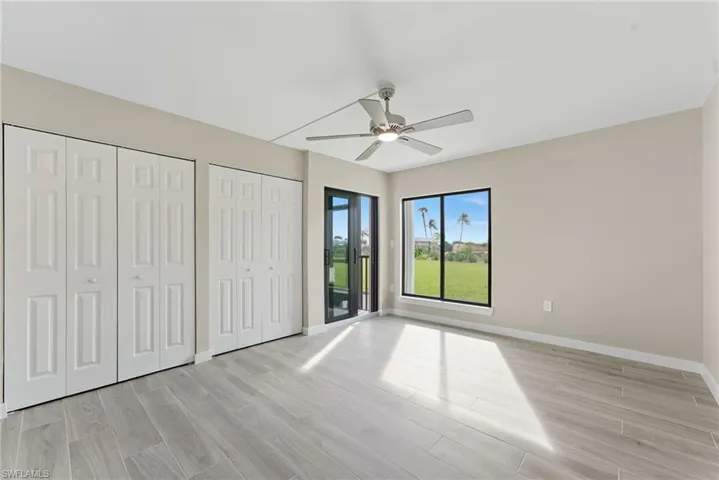 Unfurnished bedroom with two closets, light wood-type flooring, access to outside, and ceiling fan