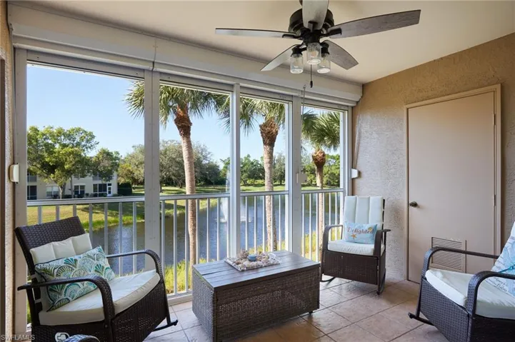 Sunroom featuring a water view and ceiling fan