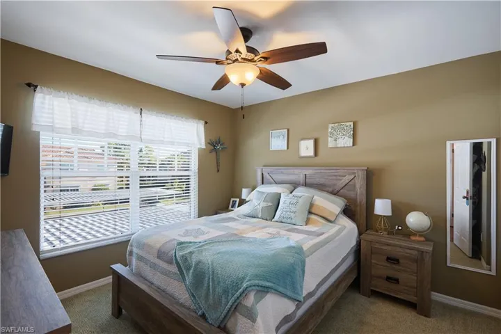 Carpeted bedroom featuring ceiling fan