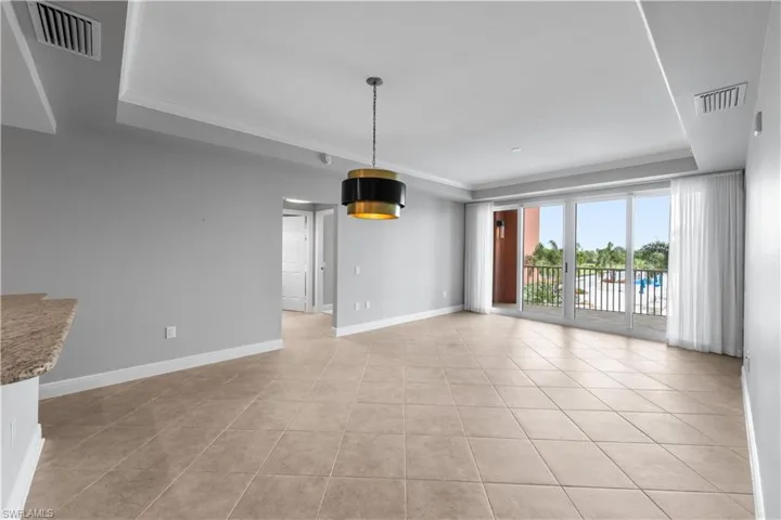 Living room with crown molding and light tile patterned floors