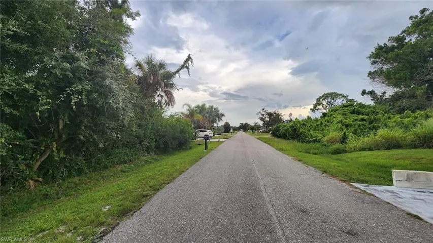 View of asphalt road featuring view of scattered trees