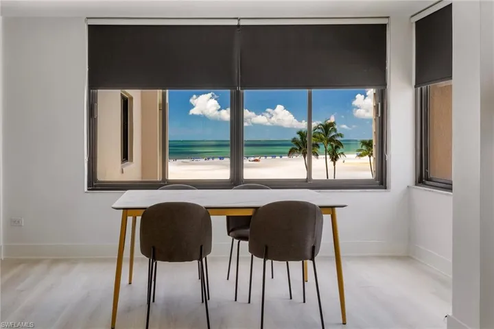 Dining area with light wood-style floors and view of water and beach