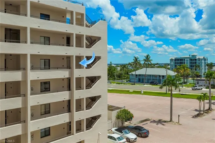 View of apartment building / complex featuring uncovered parking