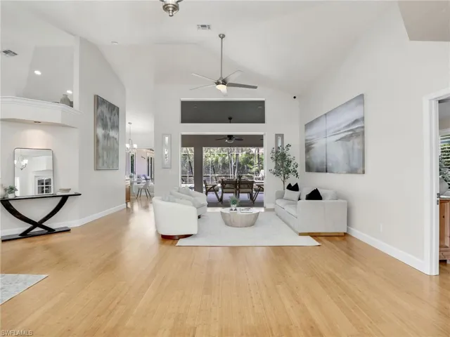 Living room featuring ceiling fan, high vaulted ceiling, and wood-type flooring