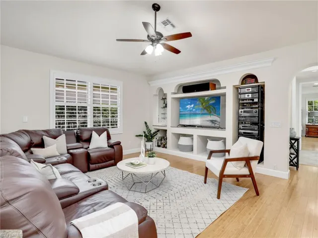 Living room with ceiling fan, light hardwood / wood-style flooring, and vaulted ceiling