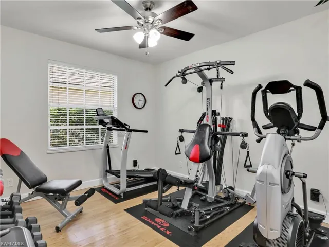 Bedroom with ceiling fan, light wood-type flooring, and stacked washer and clothes dryer