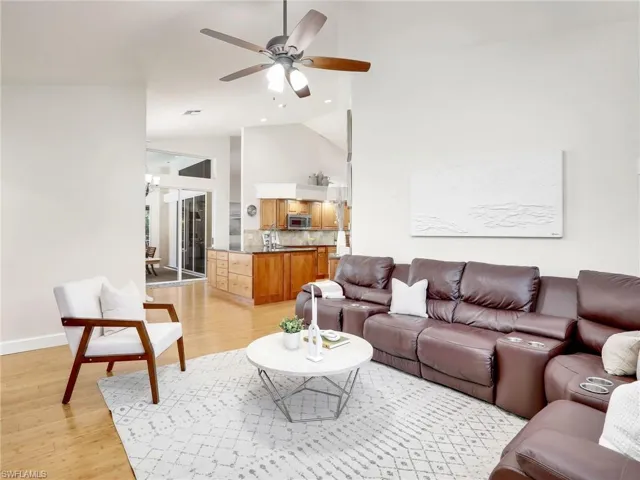 Living room with ceiling fan and light hardwood / wood-style floors