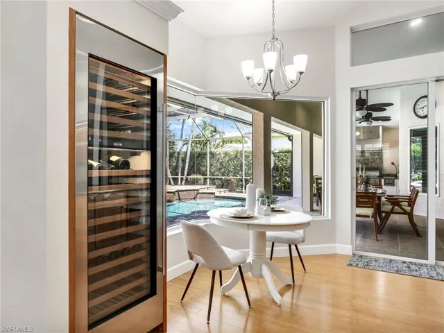 Dining area with ceiling fan with notable chandelier and light hardwood / wood-style floors