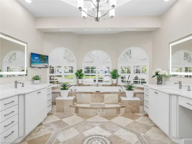 Bathroom featuring a tray ceiling, crown molding, and a shower with shower door