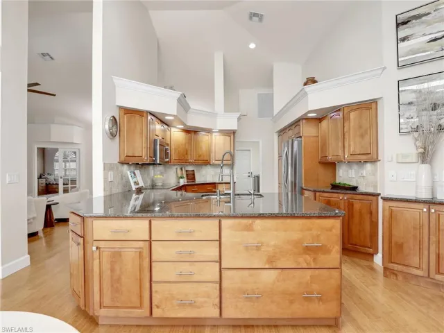 Dining space featuring wine cooler, ceiling fan with notable chandelier, and light hardwood / wood-style floors
