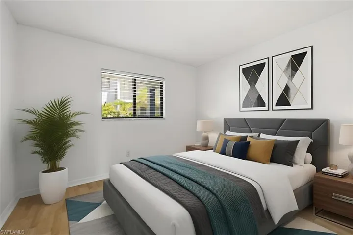 Bedroom featuring wood-finish flooring and a window with horizontal blinds